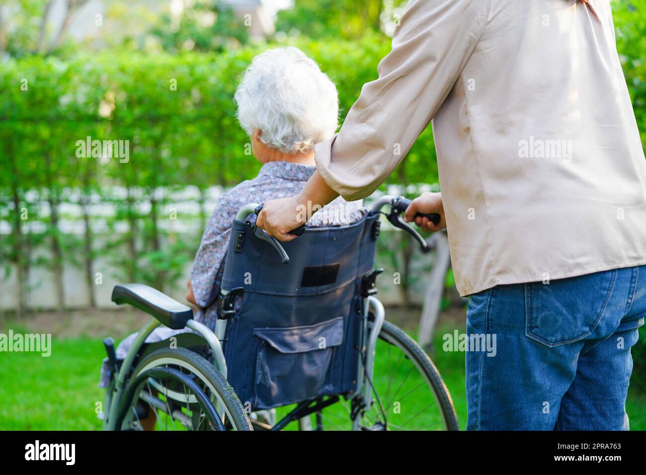 Caregiver help Asian elderly woman disability patient in nursing