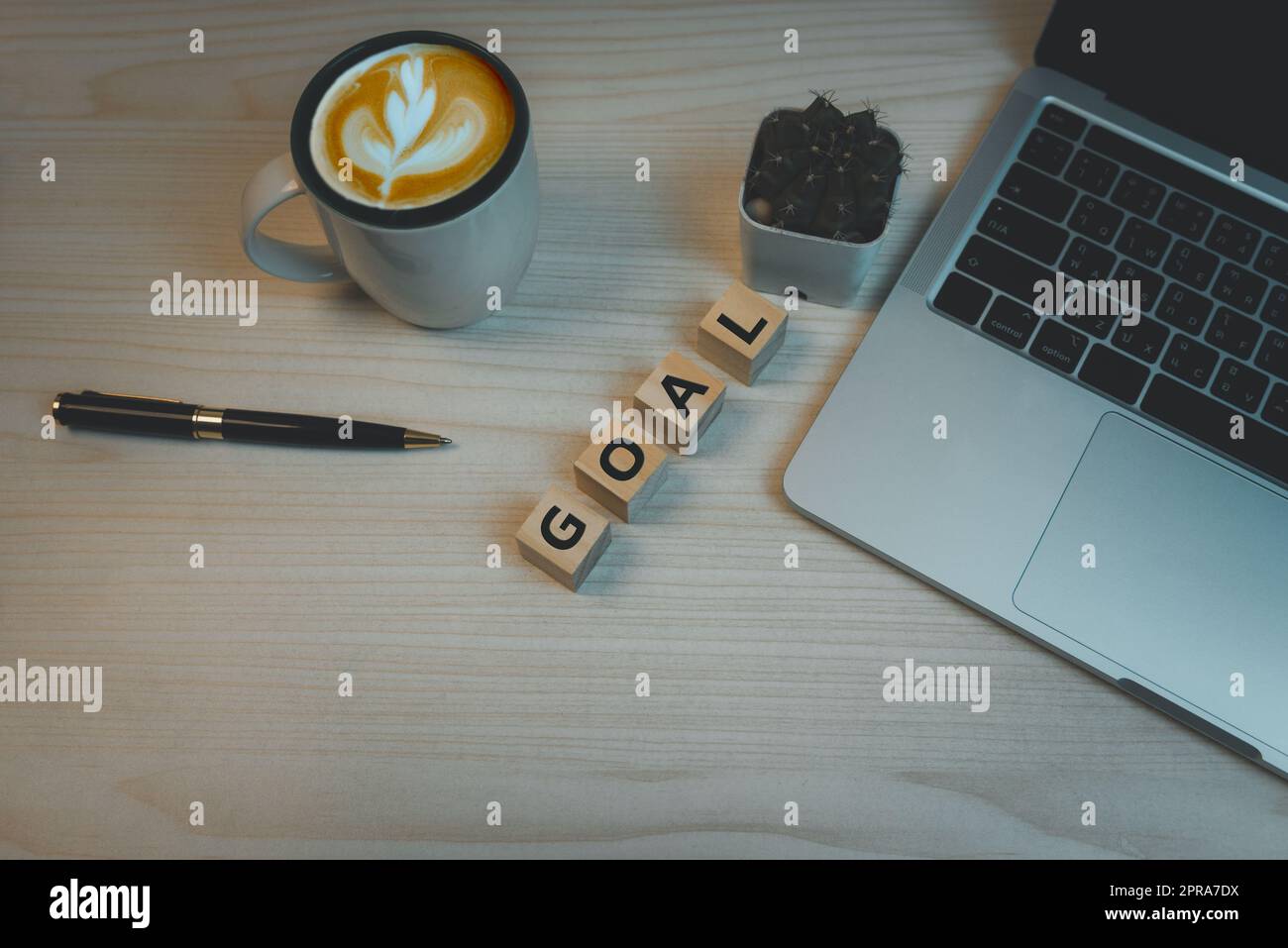 Wood cube block goal and pen coffee with computer laptop on table top view background.Copy space business idea plan success concept. Stock Photo