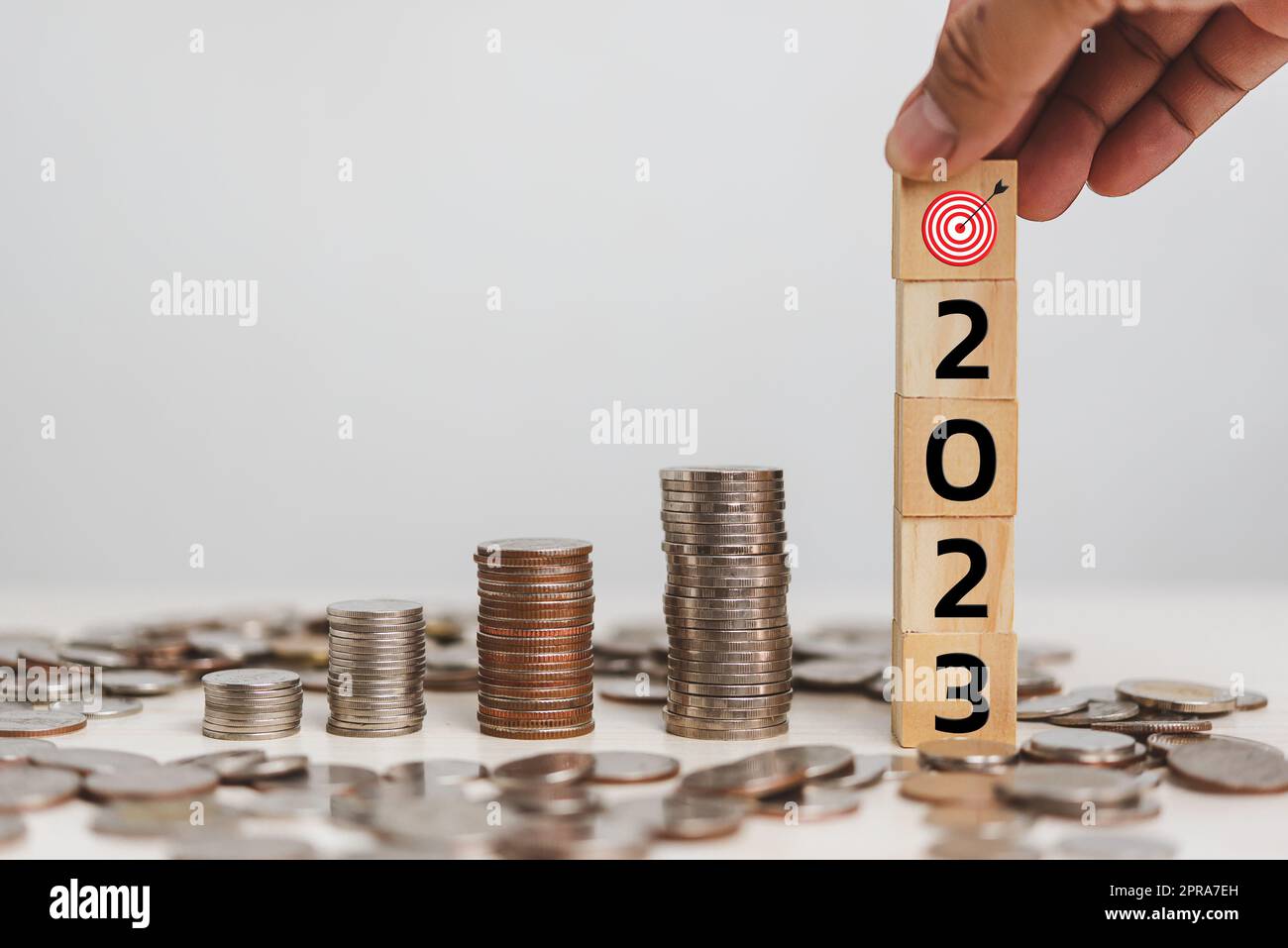Hand hold wood cube block target 2023 and money coin financial business economy investment and management accounting on table concept. Stock Photo