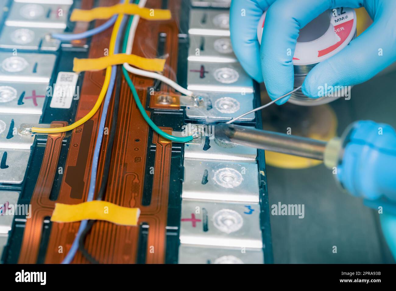 Technician use soldering iron to solder metal and wire of lithiumion