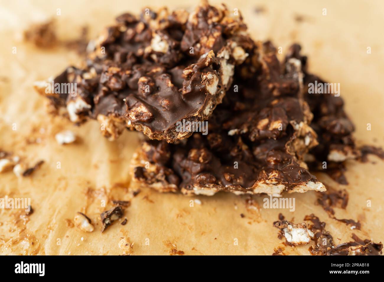 Close-up texture of peanut butter, puffed rice and chocolate, very tasty DIY dessert, dessert slices on parchment. Stock Photo