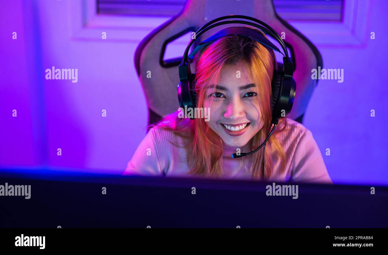 Happy Asia Girl Gamer Wear Headphone Competition Play Video Game Online  With Smartphone Colorful Neon Lights In Living Room At Home. Esport  Streaming Game Online, Home Quarantine Activity Concept. Stock Photo,  Picture
