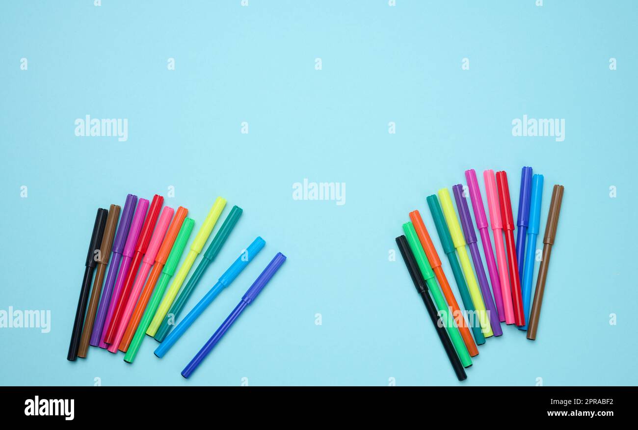 Stack of multicolored felt-tip pens on a blue background Stock Photo