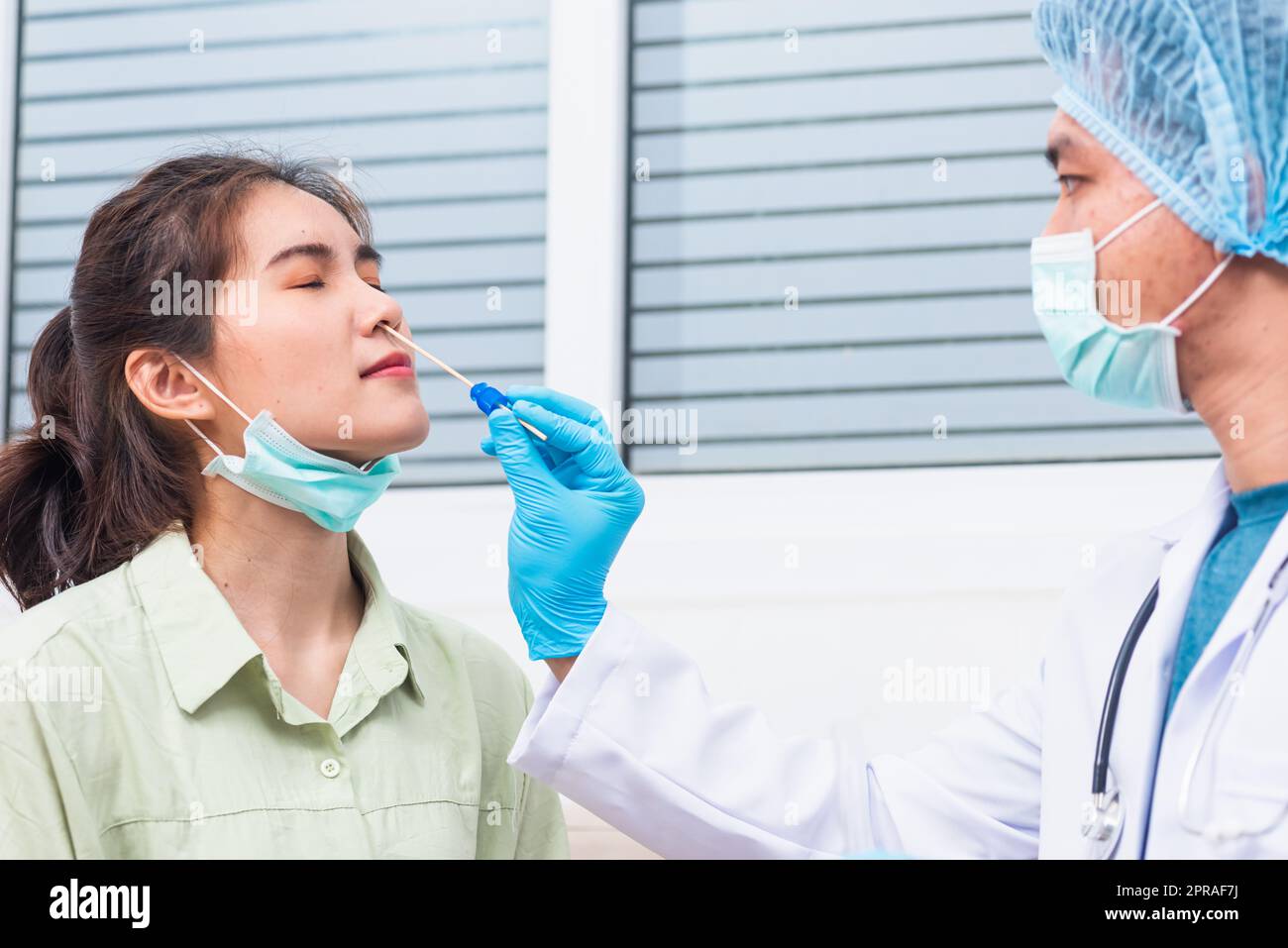 Doctor man take saliva sample through nose with cotton swab to check ...