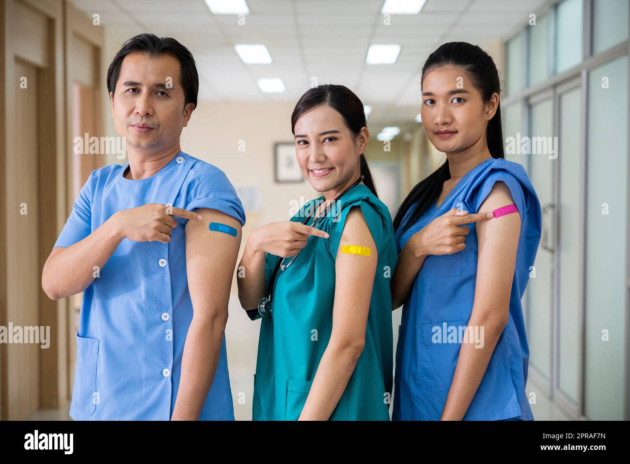 Medical personnel pointing to bandage with plaster on arm after getting against Covid-19 vaccine Stock Photo