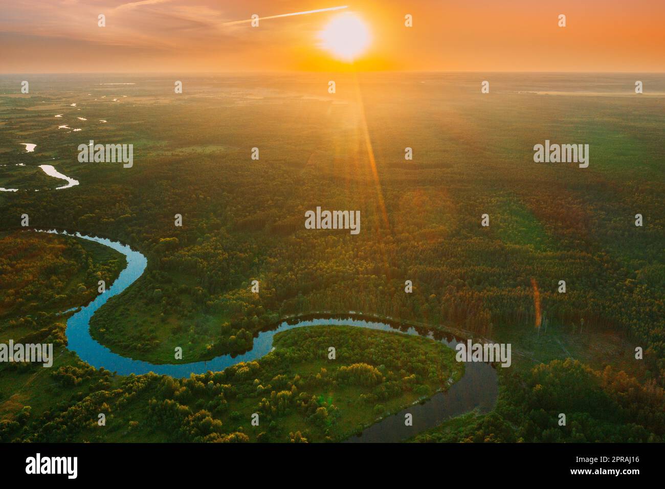 Belarus. Aerial View. Beautiful Sunset Sun Sunshine Above Summer Green Forest And River Landscape In Sunny Evening. Top View Of European Nature From High Attitude In Summer Sunrise. Bird's Eye View Stock Photo