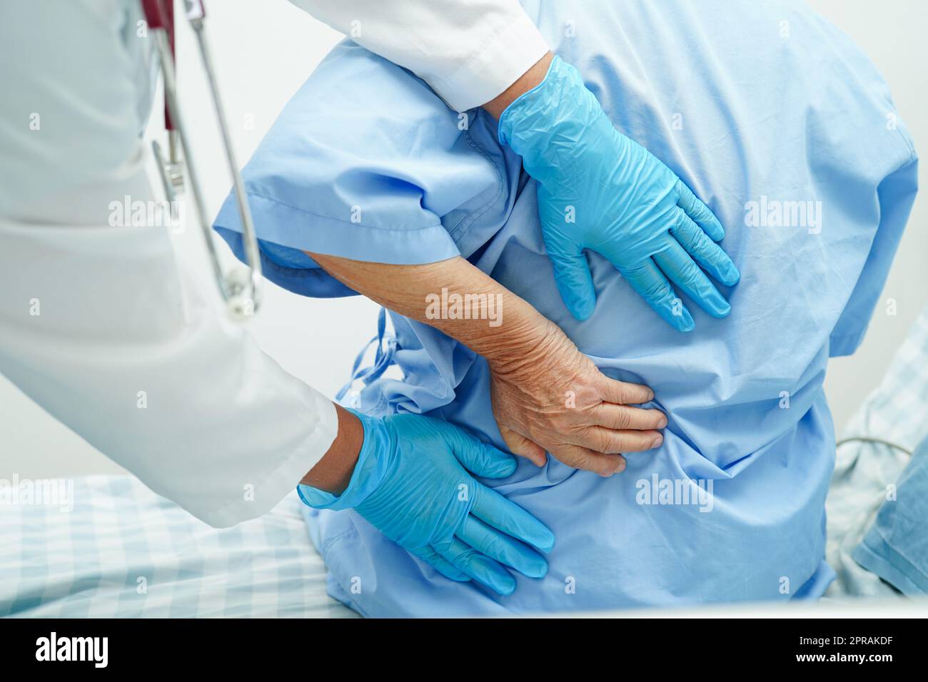 Doctor examine and treat asian elderly patient muscle back pain problem