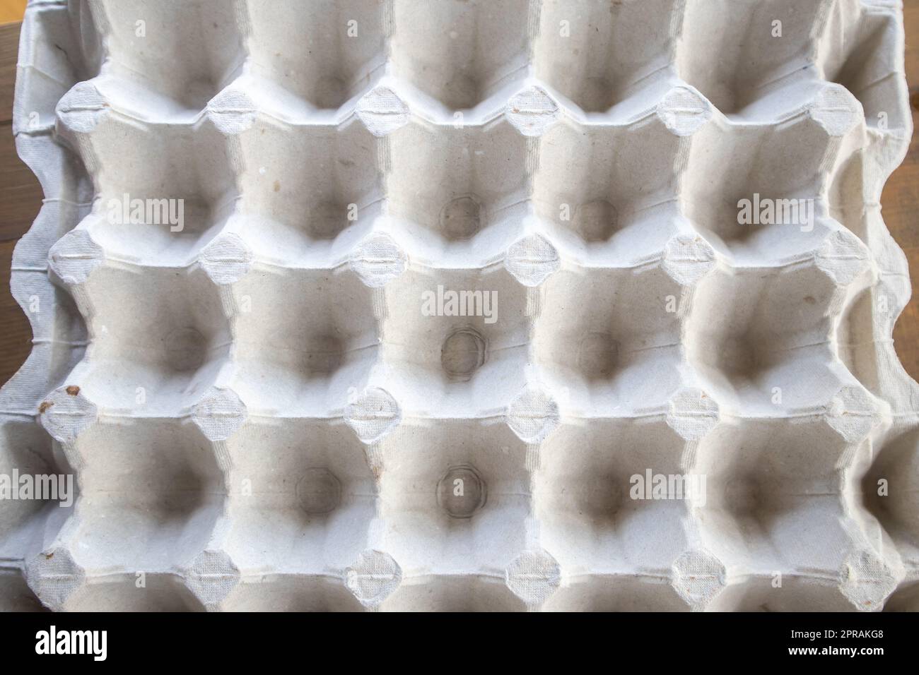 Top view of an empty cardboard egg tray. Background texture of a container made of biodegradable paper packaging with a repeating pattern Stock Photo