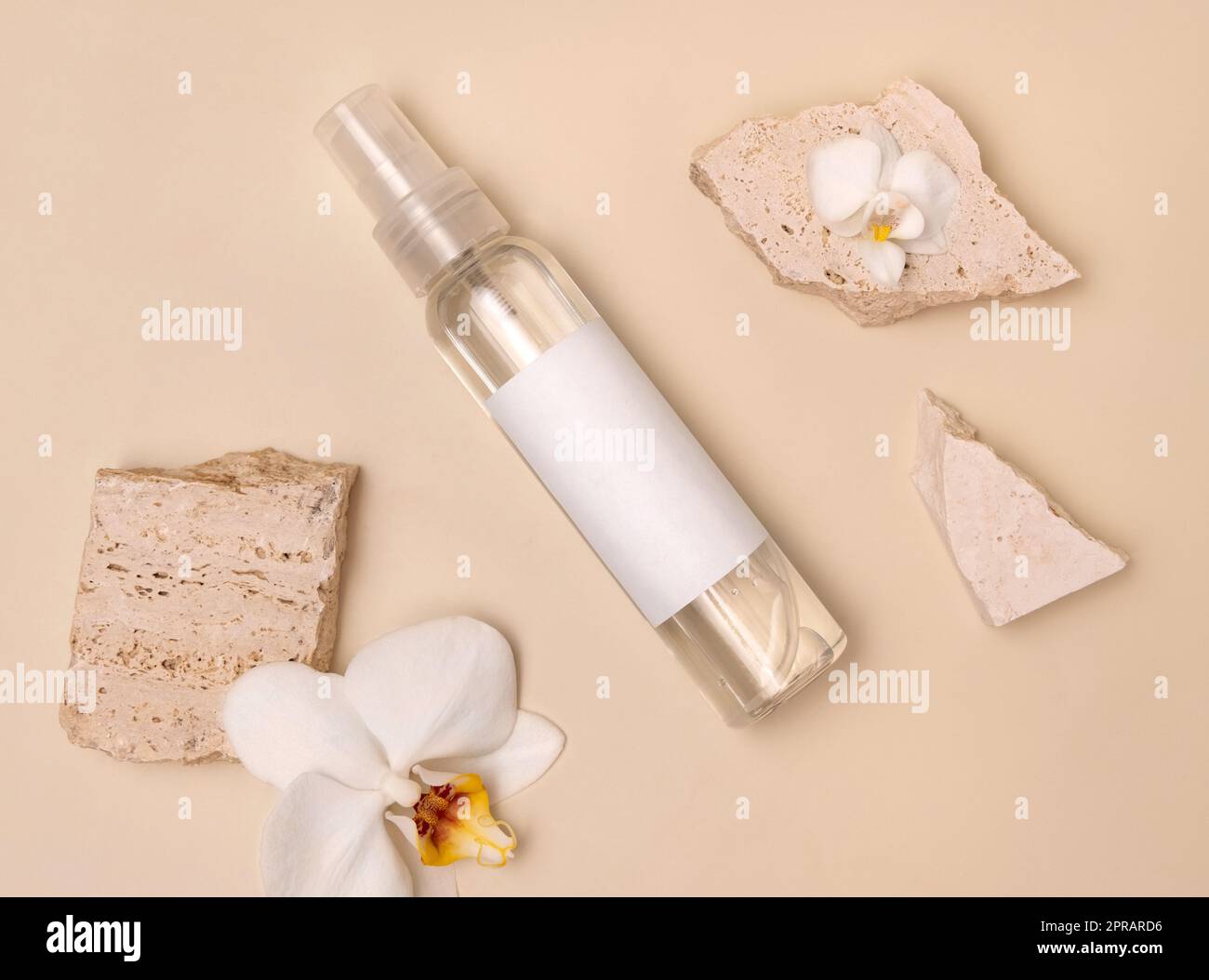Spray dispenser bottle near white orchid flowers and stones on light beige top view, Mockup Stock Photo