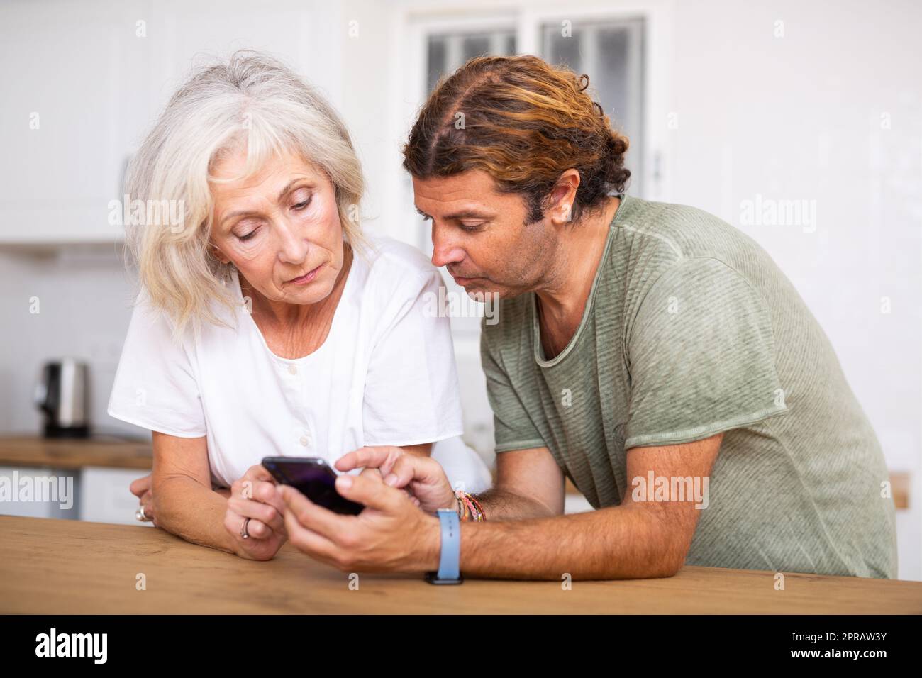 Husband help an elderly wife learn how to use smartphone Stock Photo