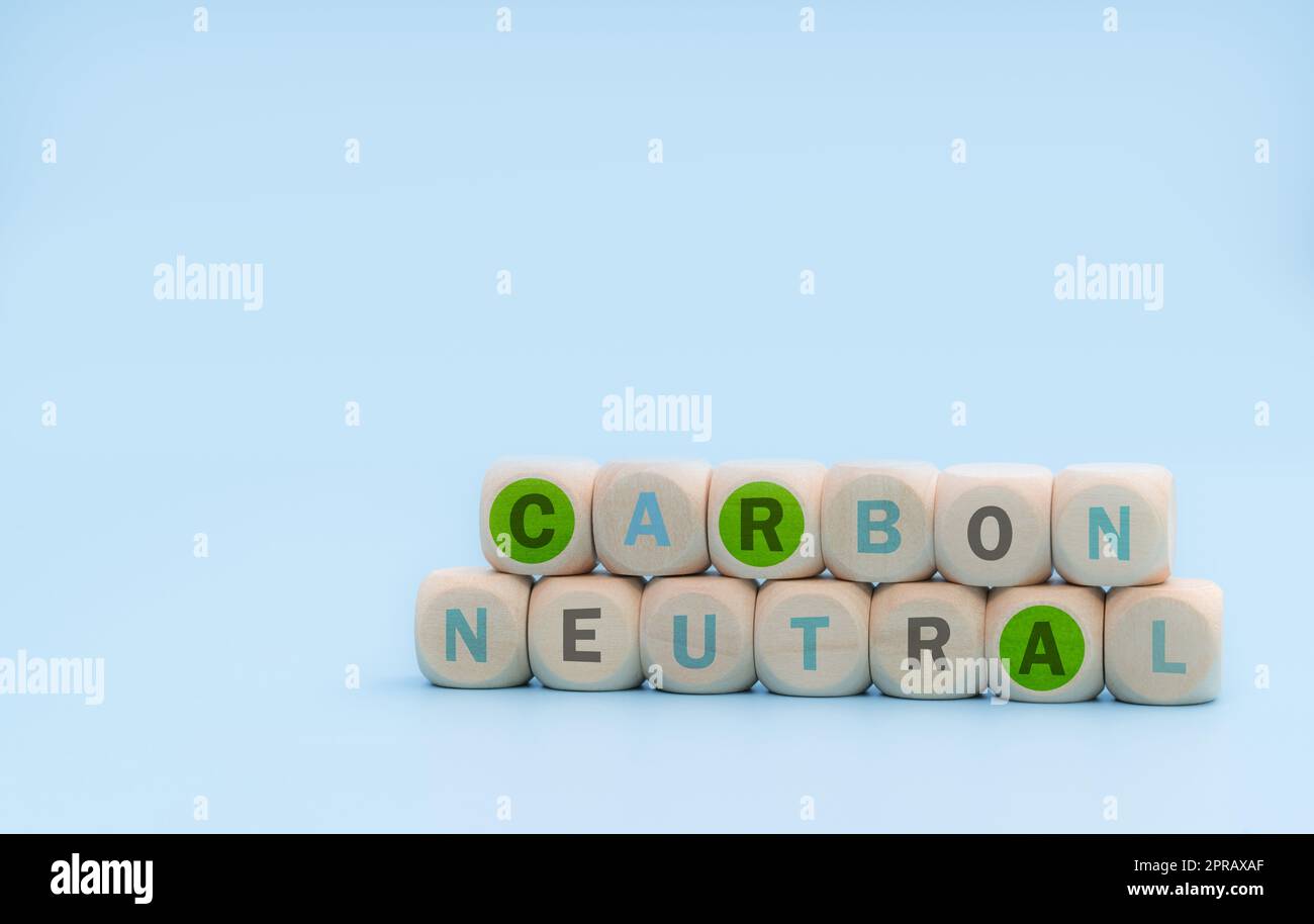 Carbon neutral concept. Wooden cubes with carbon neutral words on blue background. CO2 neutral web banner. Carbon neutral corporate business long term strategy. Global carbon neutrality concept. Stock Photo
