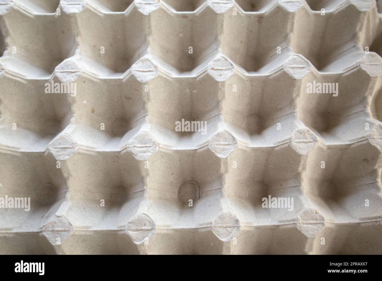 Top view of an empty cardboard egg tray. Background texture of a container made of biodegradable paper packaging with a repeating pattern Stock Photo