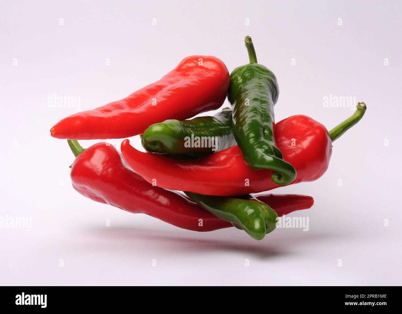 Red and green hot chili peppers on a white background with reflection ...