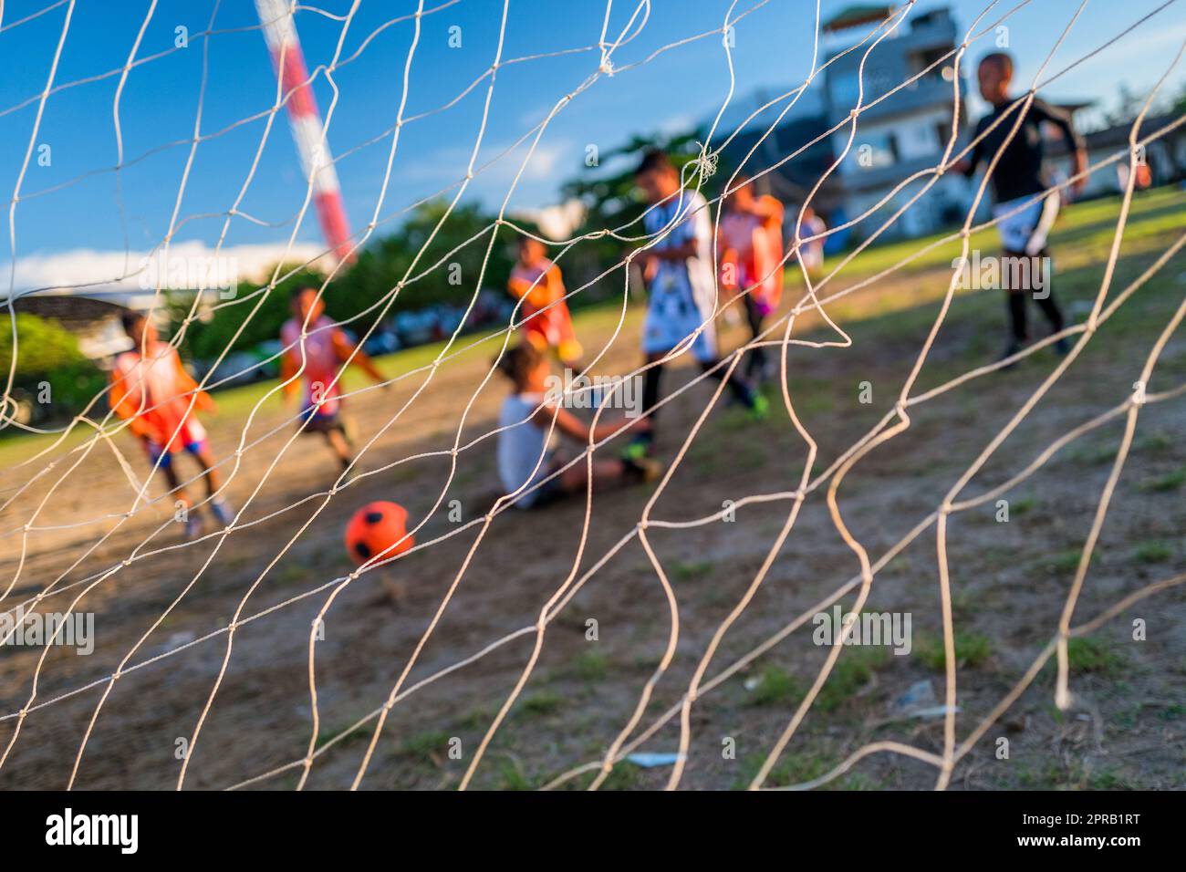 A young Afro-Colombian football player scores the goal during a training session in Necoclí, Antioquia, Colombia. Stock Photo