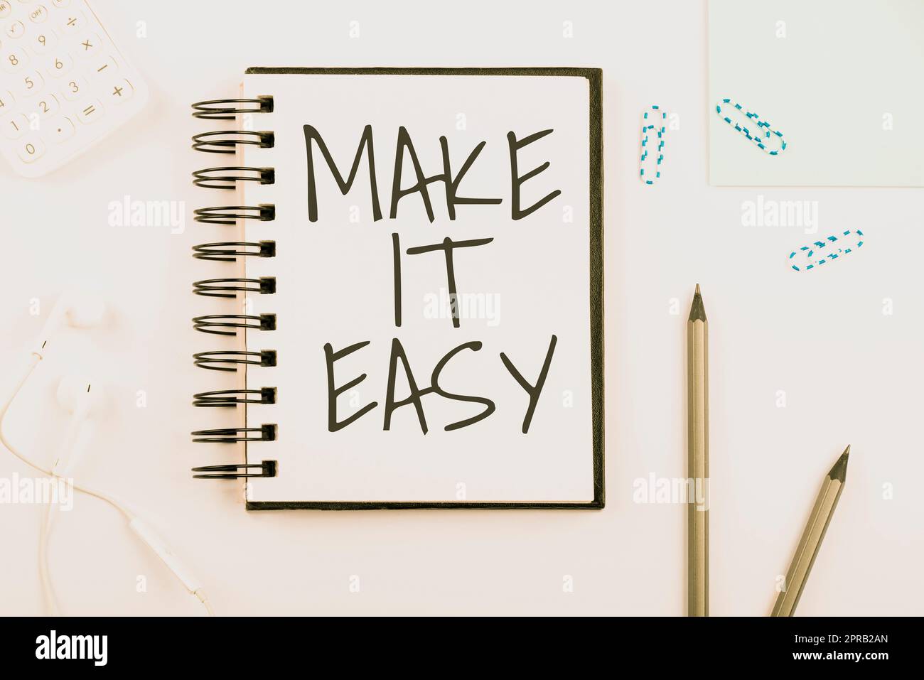 Text sign showing Make It Easy. Business approach Smart approach Effortless Free from worries or difficulties Notebook With New Message On Desk With Pens, Headphones And Paperclips. Stock Photo