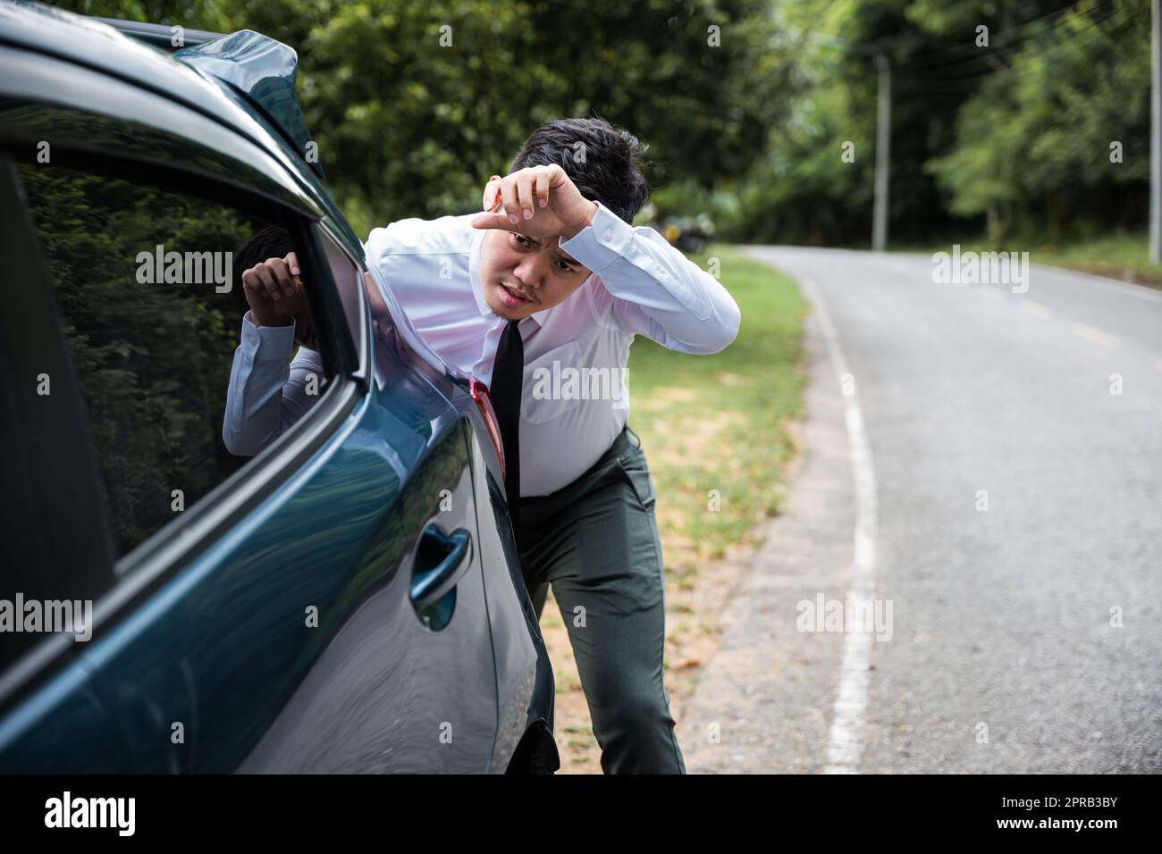 Asian businessman car broken has problems with car down during go to work in morning he pushing out of gas Stock Photo