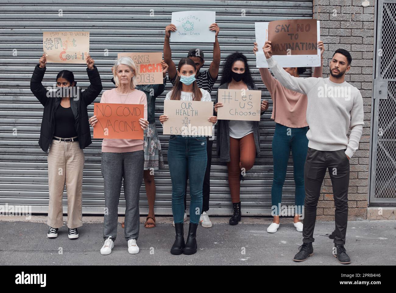 Say no to the vaccine. Full length portrait of a group of demonstrators holding up signs protesting against the covid 19 vaccine. Stock Photo