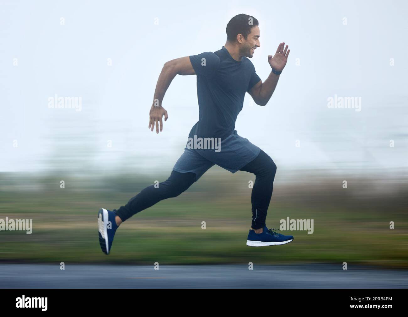 Boosting with speed in every step. a sporty young man running outdoors. Stock Photo