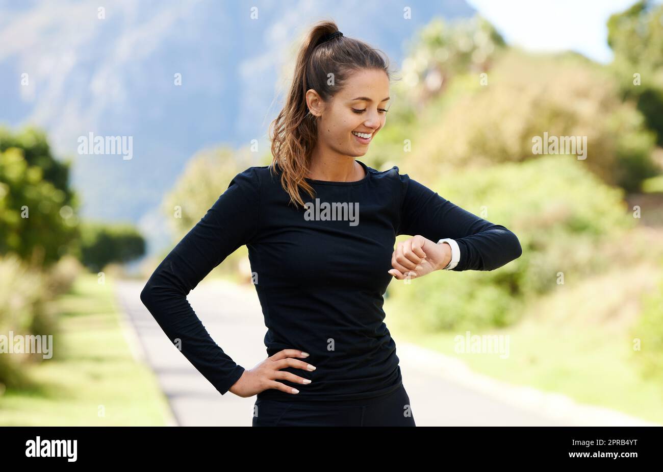 Thats a great time. an attractive and athletic young woman checking her watch while standing outdoors. Stock Photo