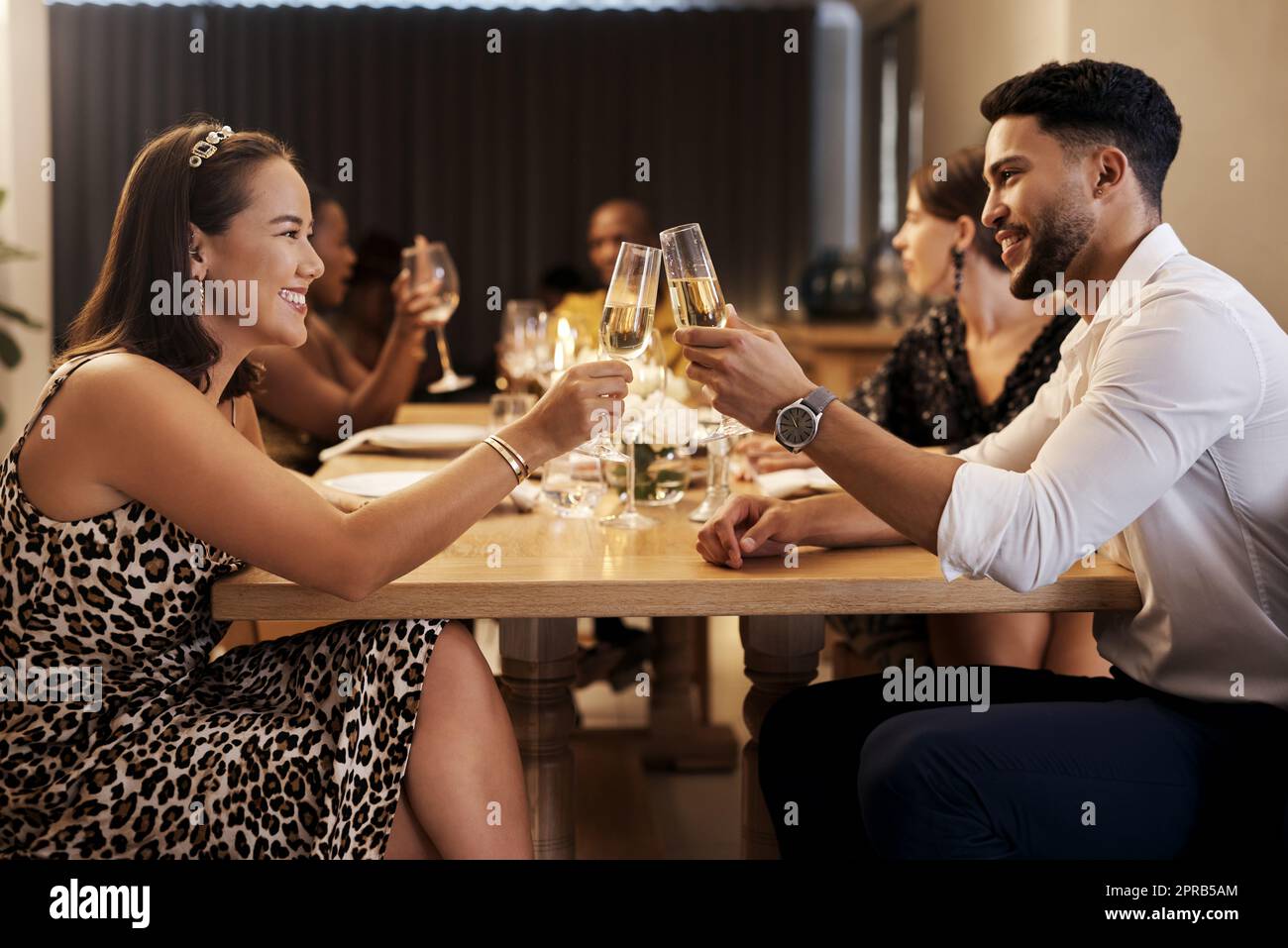 Happy New Year, babe. a happy young couple sitting together and toasting  with champagne during a New Years dinner party Stock Photo - Alamy