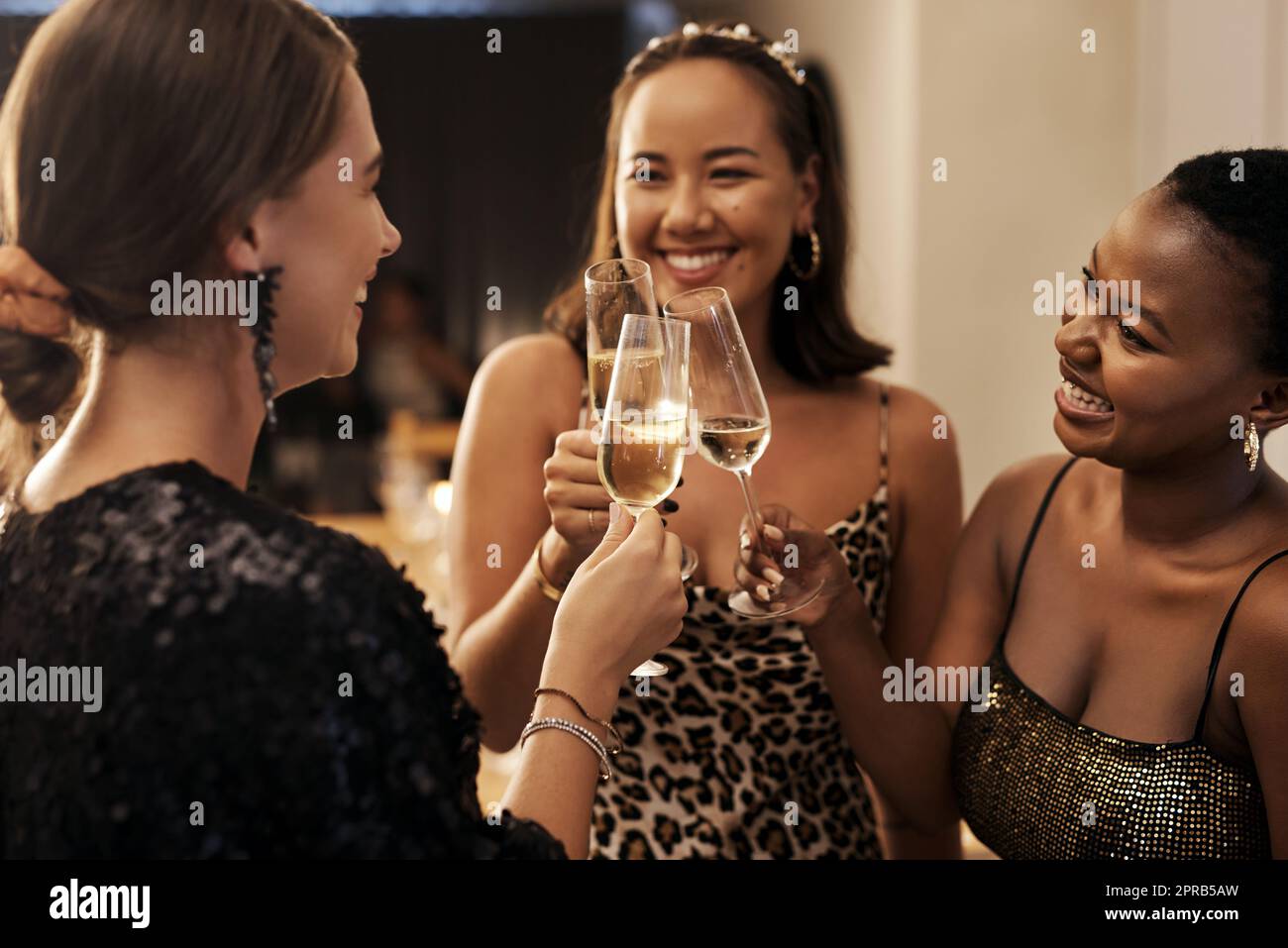 May the New Year bring us lots of adventures. a diverse group of friends standing together and toasting with champagne during a New Years dinner party. Stock Photo