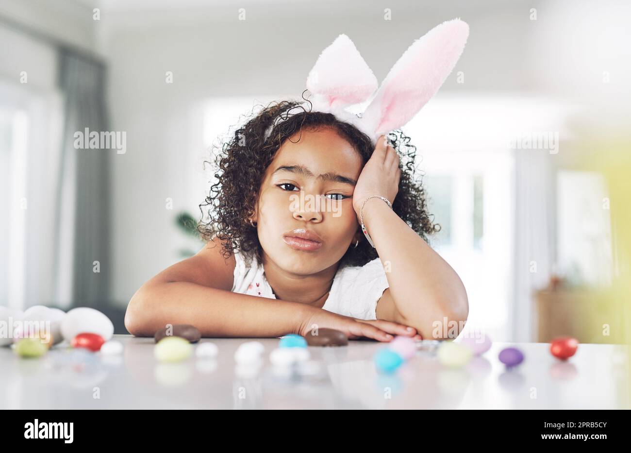 One grumpy little easter bunny. a unhappy girl sitting at home. Stock Photo
