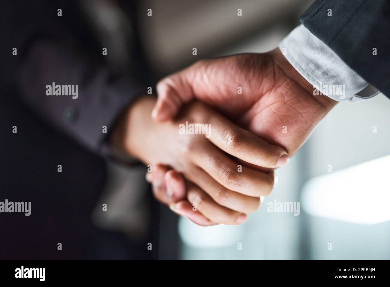 Once we shake hands , the deal is made. two unrecognizable businesspeople shaking hands in an office. Stock Photo