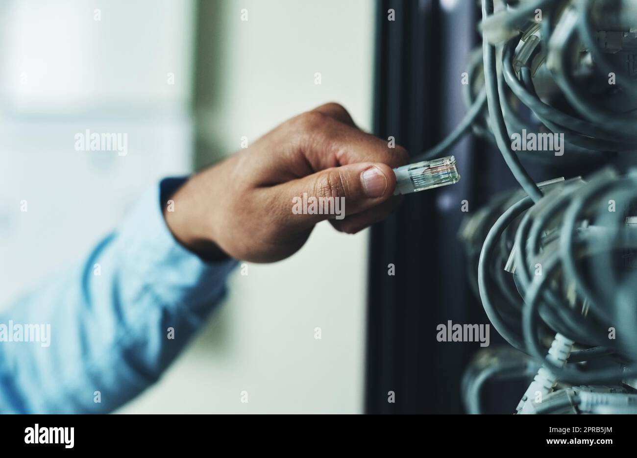 You shouldnt be here. an unrecognizable technician standing alone and adjusting the mainframe. Stock Photo