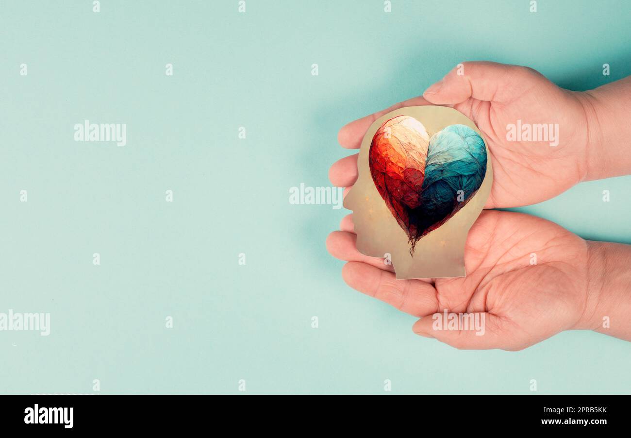 Holding a head with a colorful heart in the hands, symbol of love and positive emotion, charity and support Stock Photo