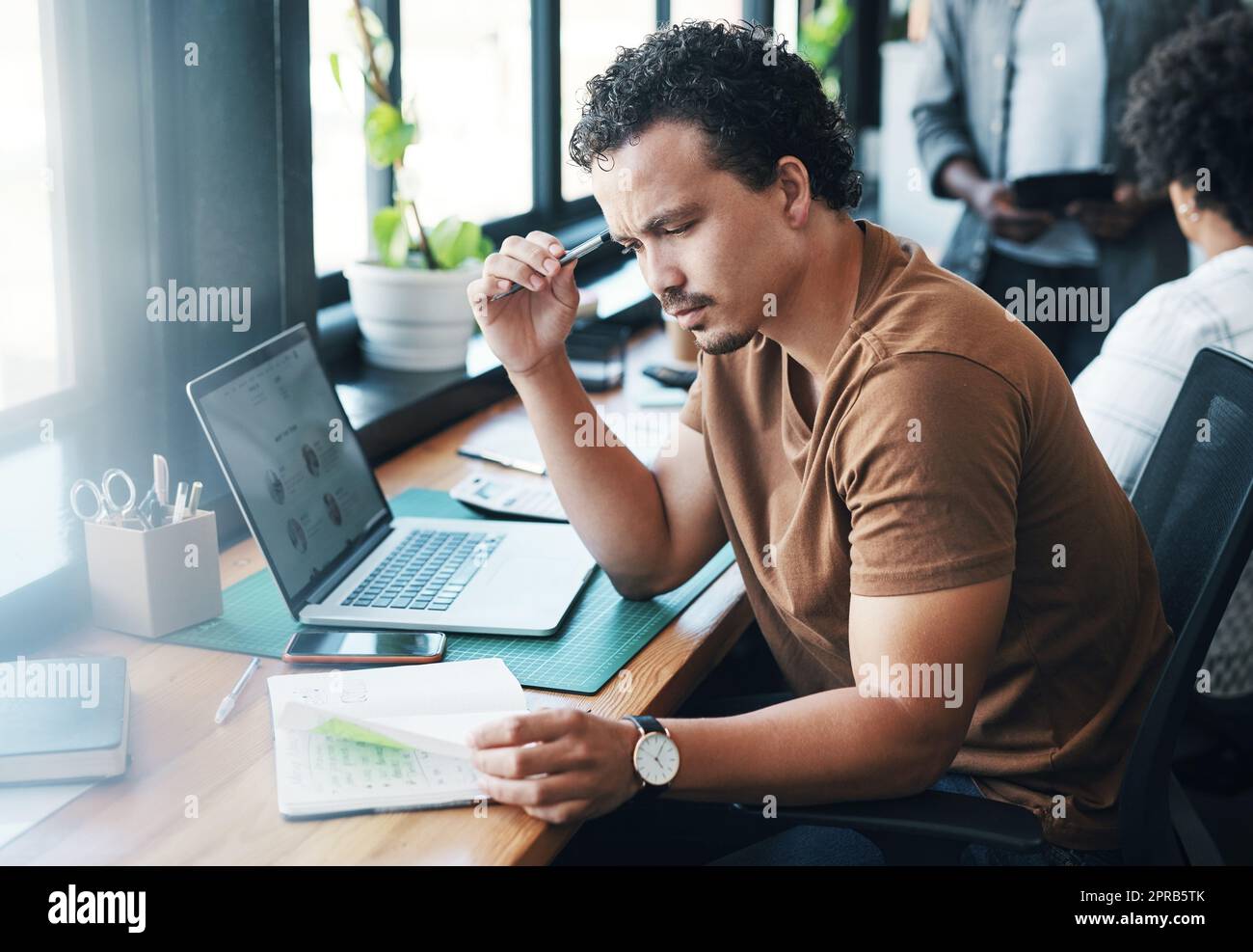 Do I have to remember all of this. a young businessman working in an office. Stock Photo