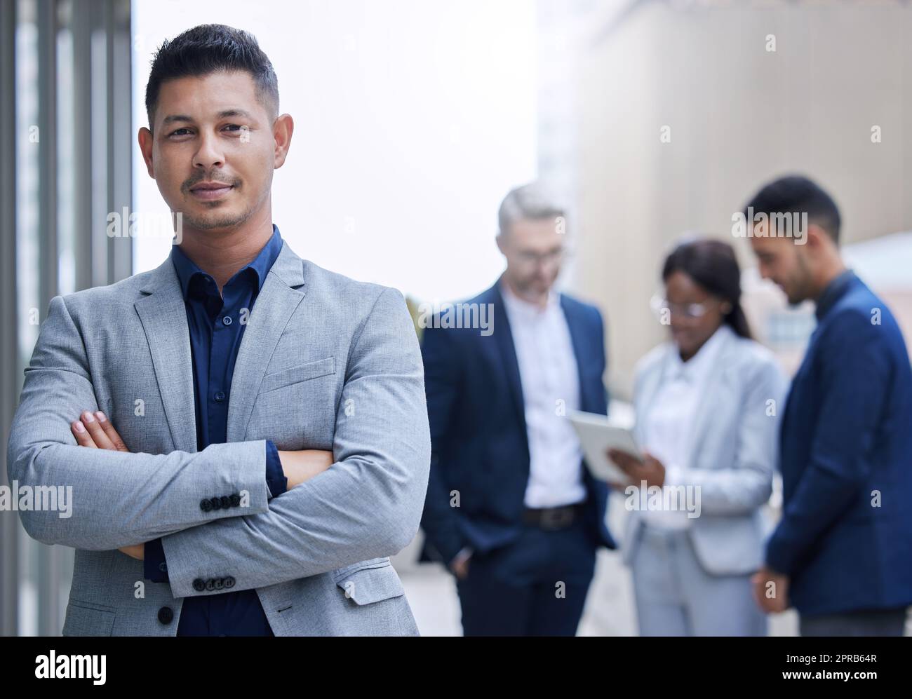Ive assembled an all-star team. Cropped portrait of a handsome mature businessman standing outside with his arms folded with his colleagues in the background. Stock Photo