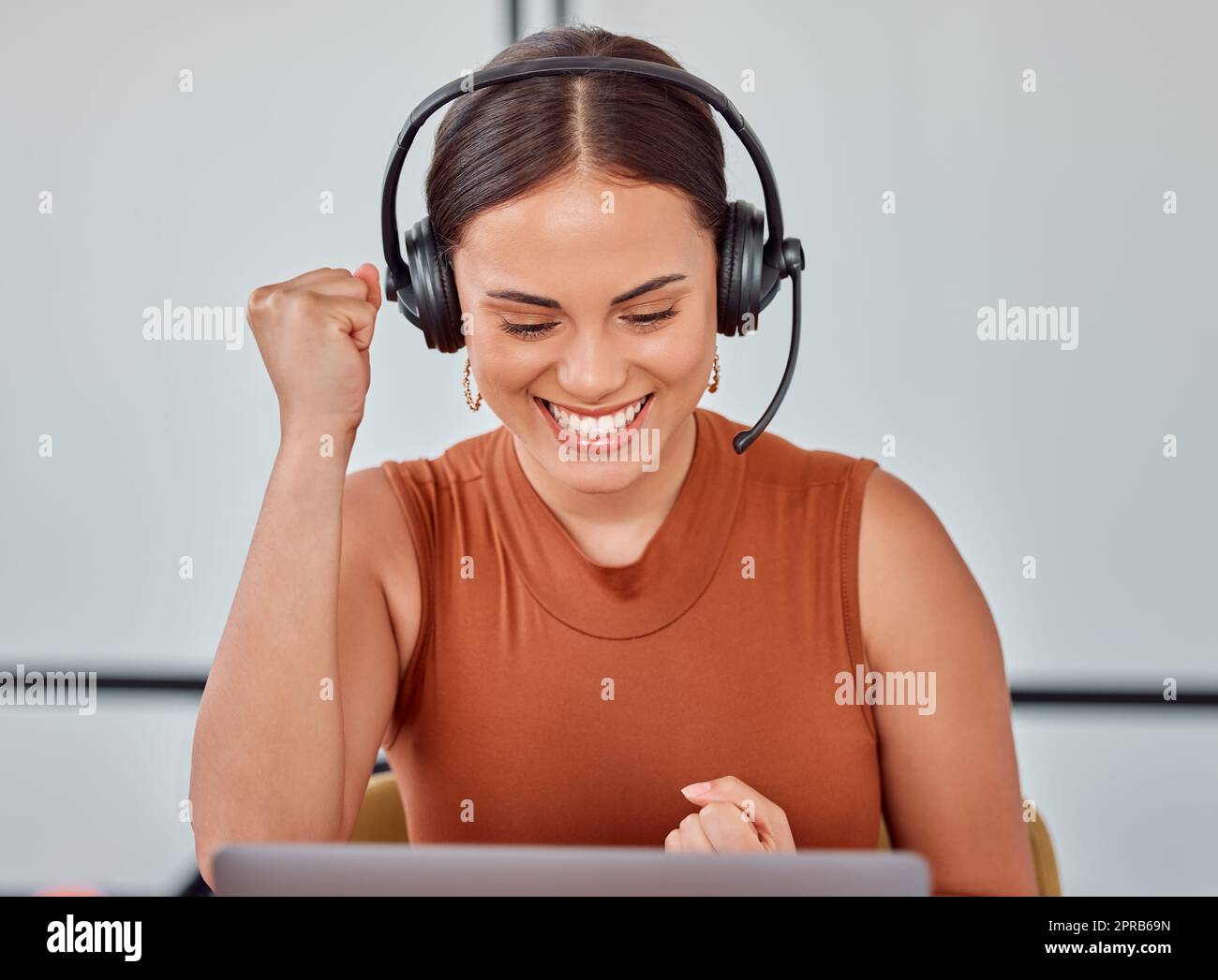 We did it. an attractive young female call center agent cheering while working on her laptop. Stock Photo