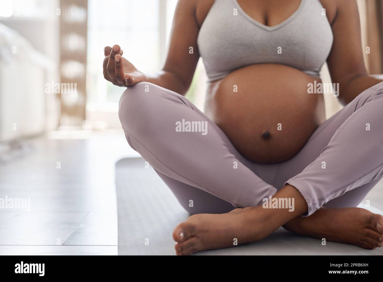 Strengthen your bond with yoga. a pregnant woman doing yoga at home. Stock Photo