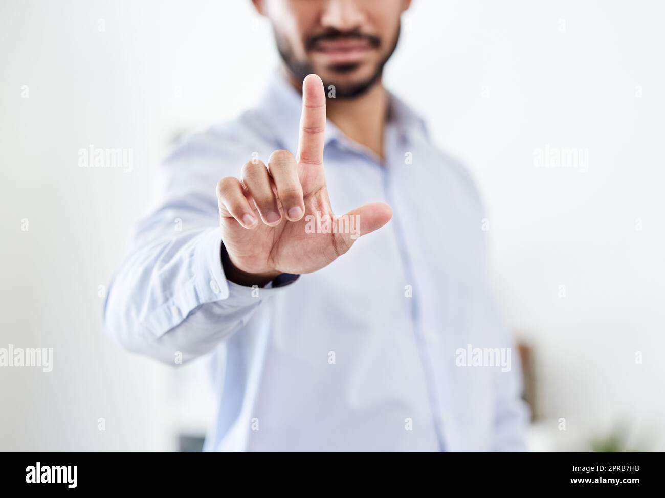 Modern, future and futuristic business man pointing his finger up pressing an empty virtual touchscreen. Closeup portrait of a corporate professional male touching an invisible screen or in an office Stock Photo
