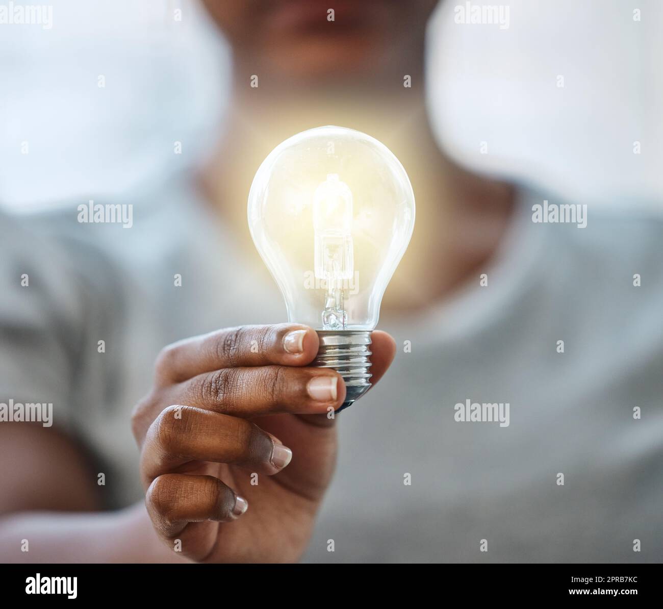 Use your knowledge to bring light to this world. an unrecognisable businesswoman holding a lightbulb. Stock Photo