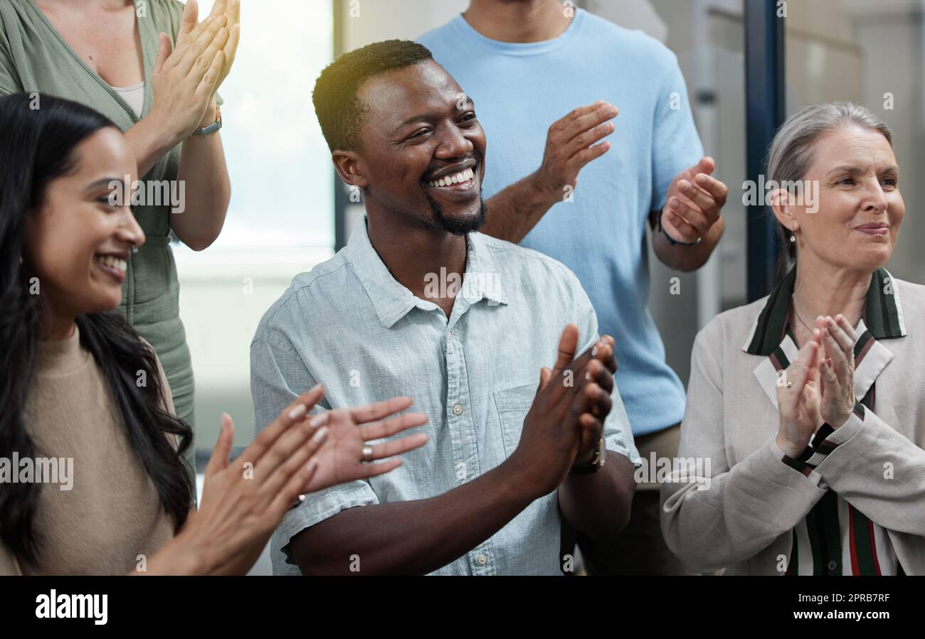 Staying inspired and in high spirits. a young businessman applauding with his colleagues in an office. Stock Photo
