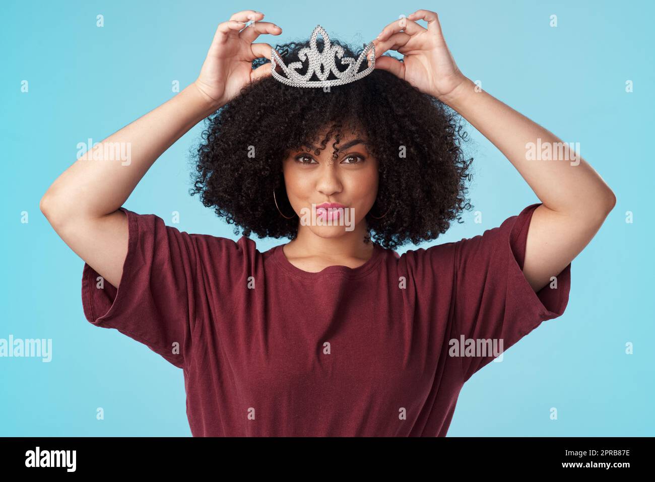Fix your crown, never let it fall. Studio shot of a young woman putting