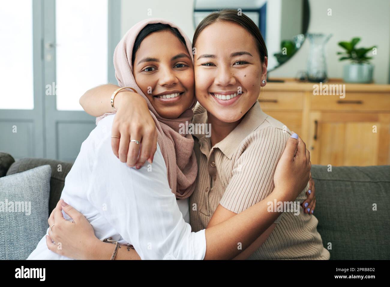 I couldnt do life without my best friend. two young women sitting on the sofa together at home and hugging. Stock Photo