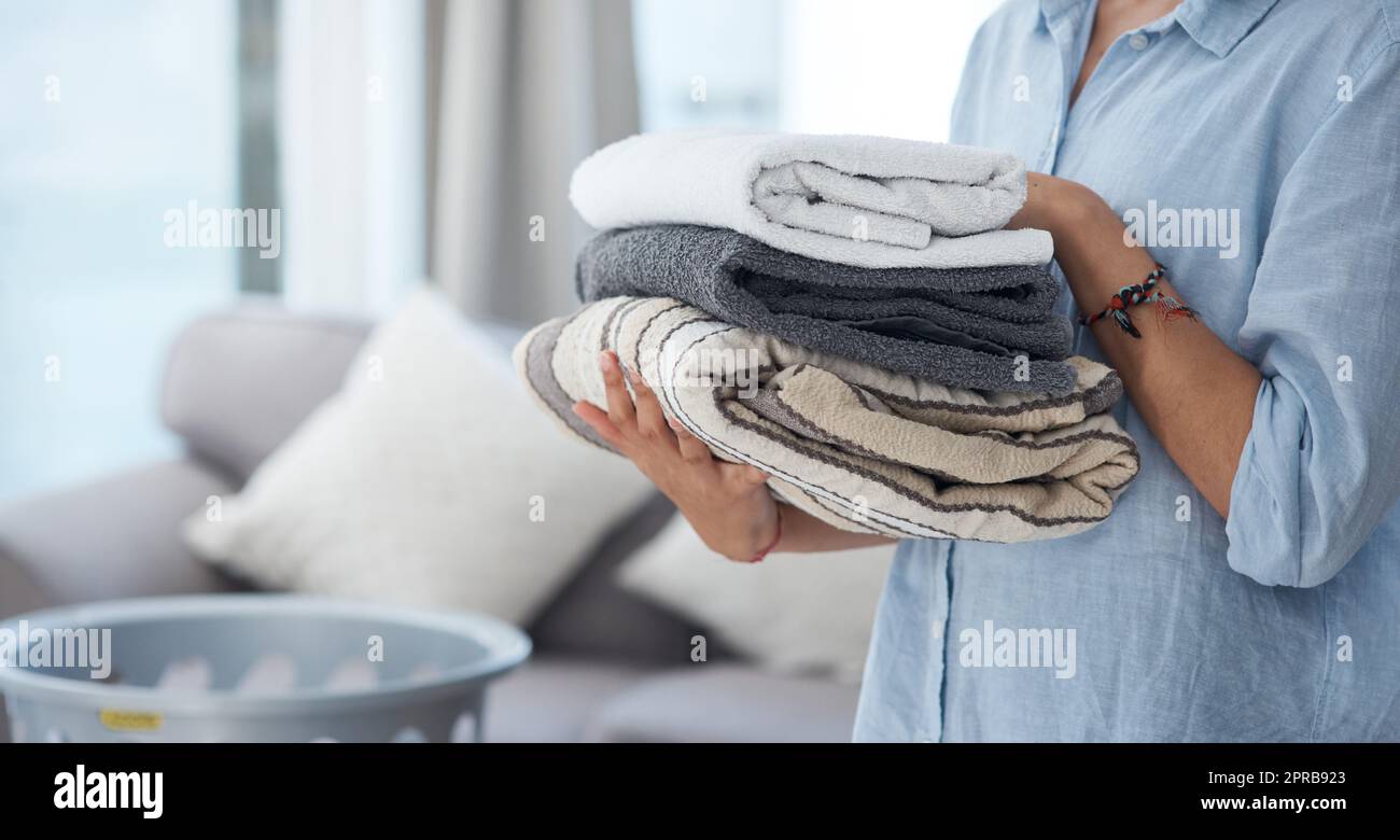 Doing laundry is soothing to me. an anonymous woman holding a pile of clean neatly folded laundry. Stock Photo
