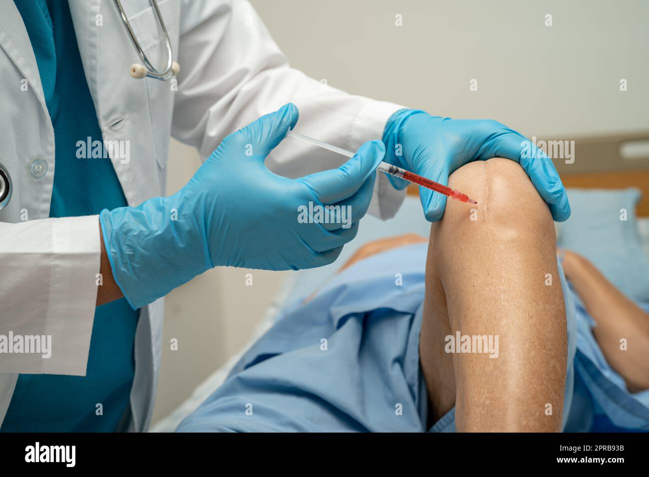 Asian doctor inject Hyaluronic acid platelet rich plasma into the knee of senior woman to walk without pain. Stock Photo