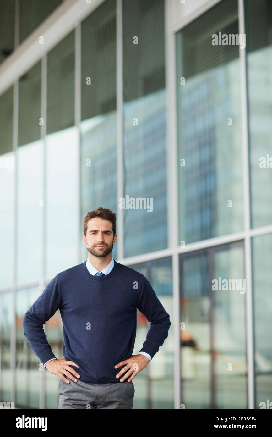 Im ready for whatever challenges lie ahead. Cropped portrait of a handsome young businessman standing alone outside with his hands on his hips. Stock Photo
