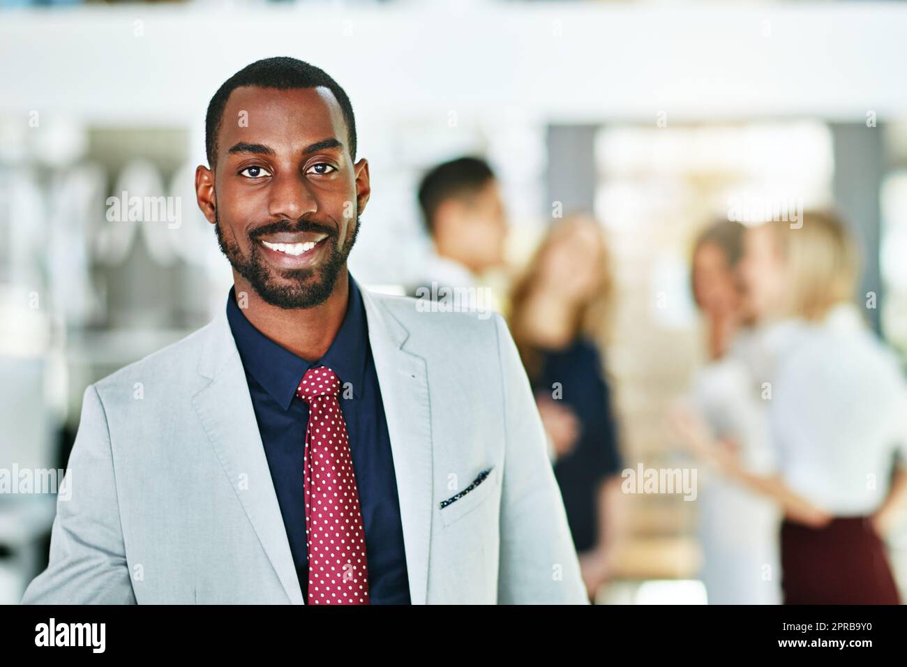 Manager, leader and boss standing with diverse team of executives in office background. Portrait of confident, successful or proud ceo with happy, smiling and cheerful face expression after a meeting Stock Photo