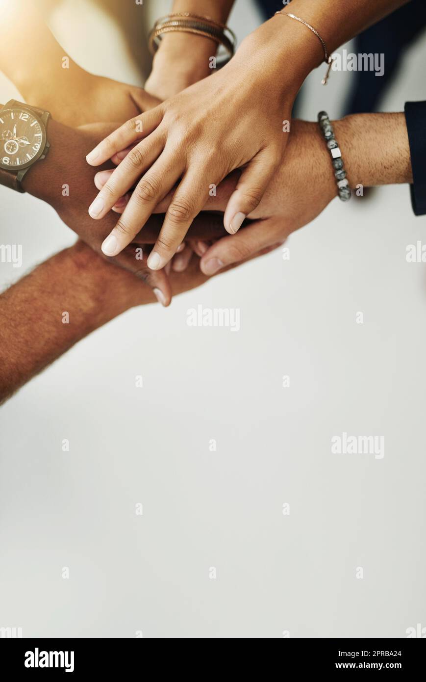 Hands in a huddle for teamwork, unity and working together from above. Closeup of a diverse group or team collaborating, joining and connected as a united people, showing solidarity and cooperation Stock Photo
