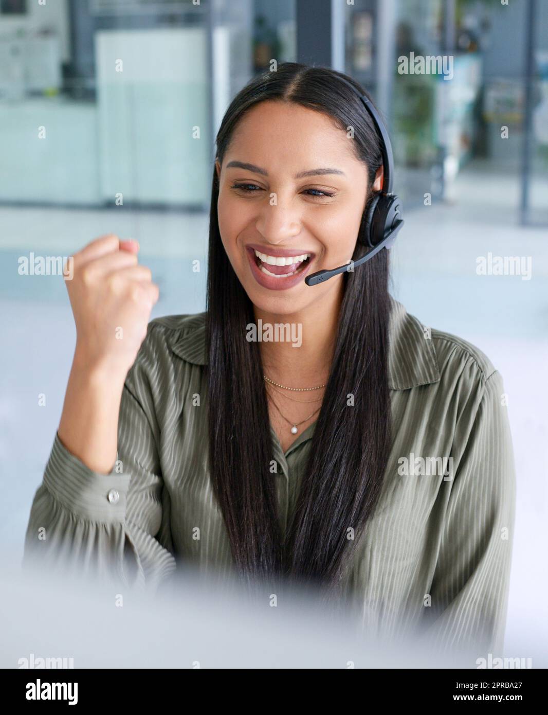 Big sales means bagging a big commission. a young call centre agent cheering while working in an office. Stock Photo