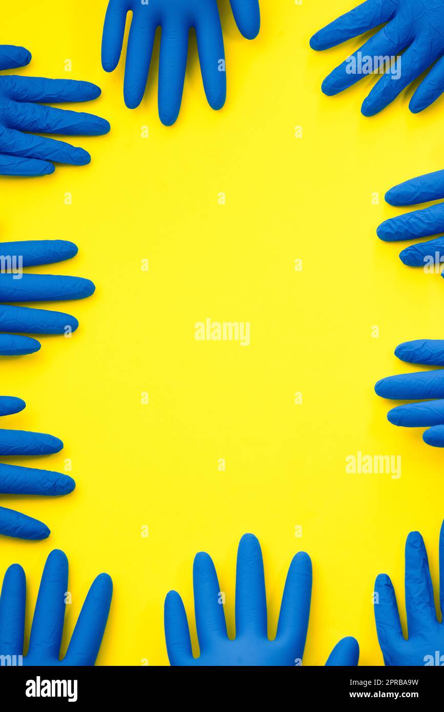 Grab a glove and get to work. Studio shot of rubber gloves against a bright yellow background. Stock Photo