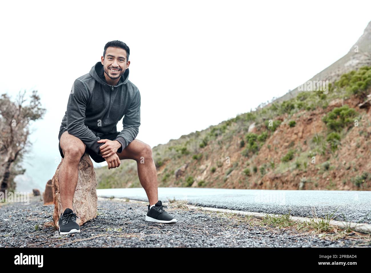 I came out for some solo cardio along the scenic route. Portrait of a sporty young man taking a break while exercising outdoors. Stock Photo
