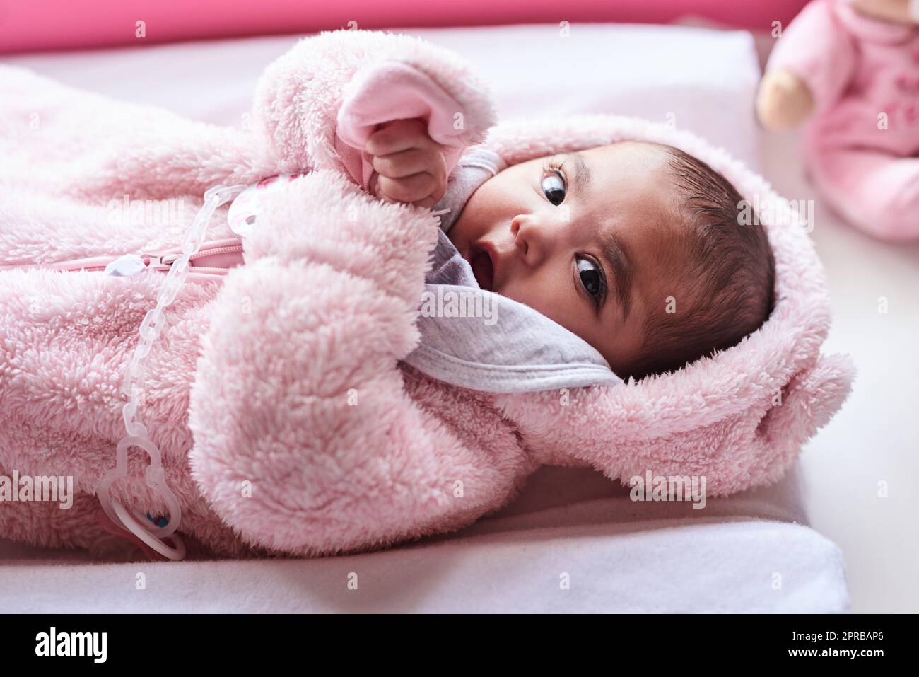 I think my name is Cute, everyone calls me that. an adorable baby girl on a diaper changing station at home. Stock Photo