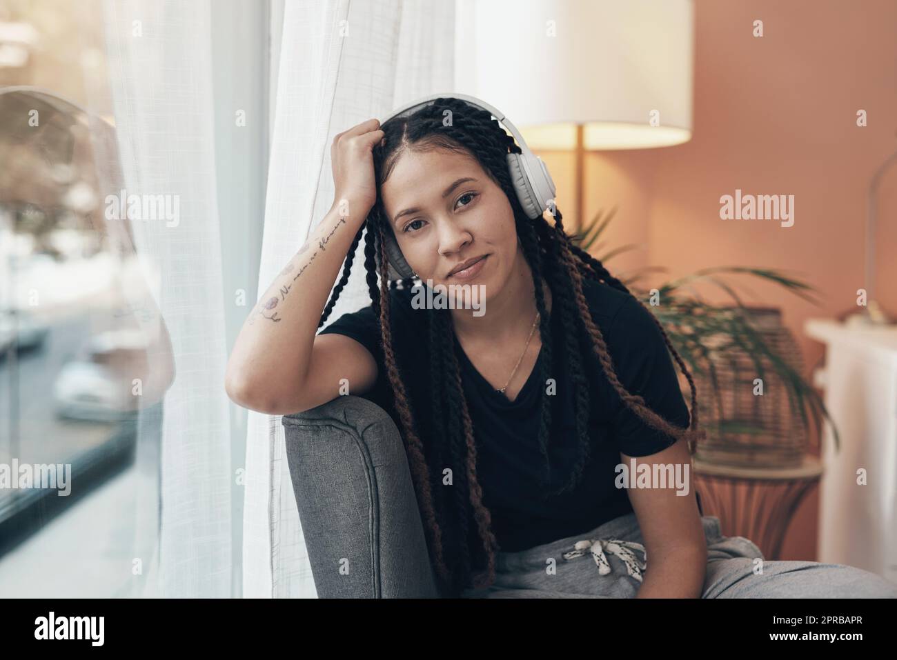 When life slows down, I turn the beat up. Portrait of a young woman using headphones at home. Stock Photo