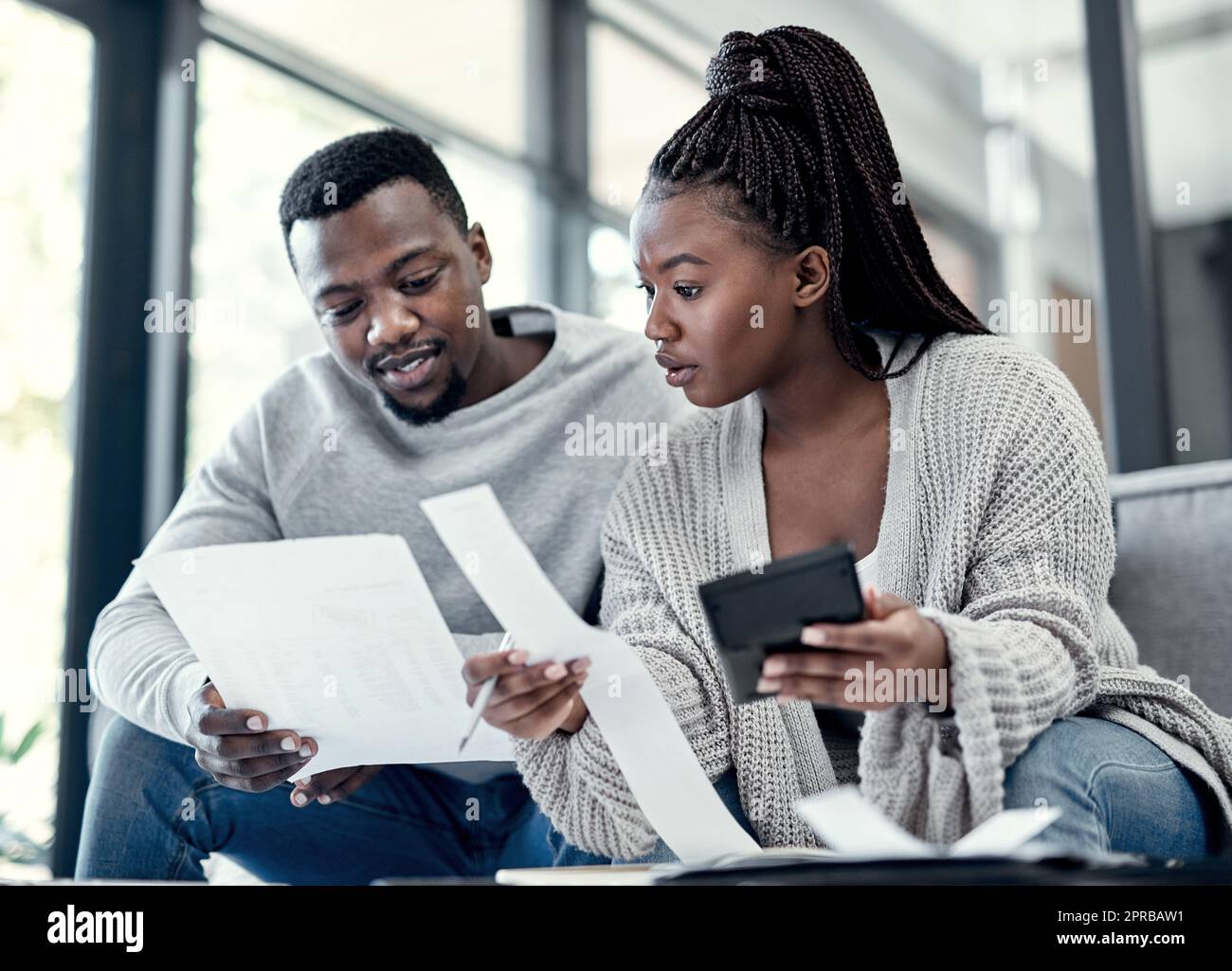 Were going to have cut back this month. a young couple going through paperwork at home. Stock Photo