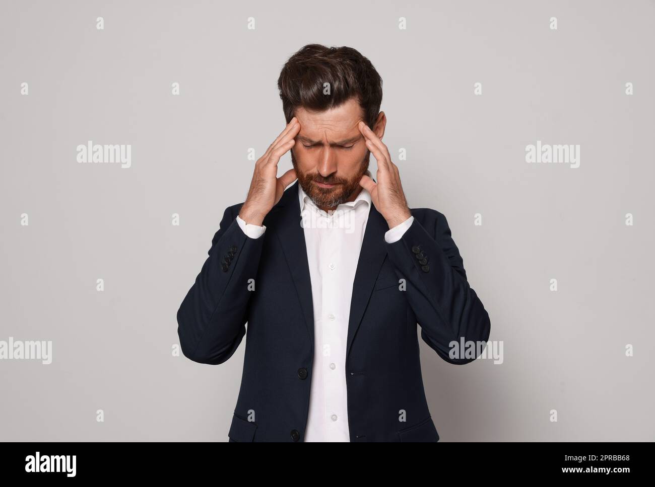 Worried bearded man on light grey background Stock Photo